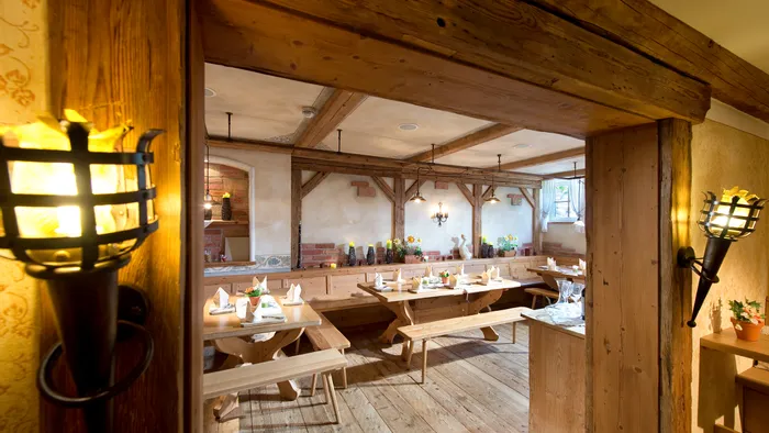 Rustikales Holzrestaurant mit gedeckten Tischen und warmer Ambientebeleuchtung
